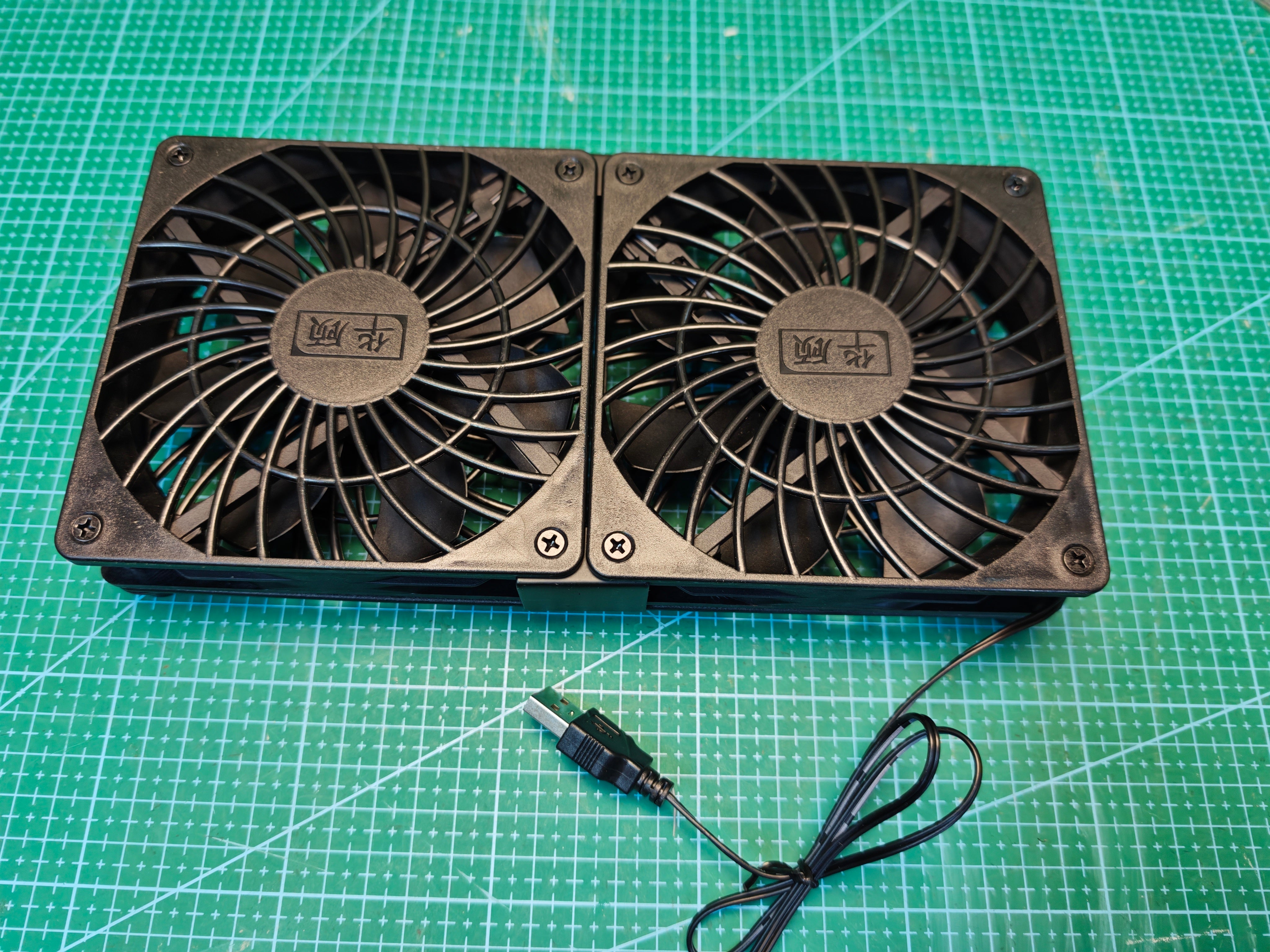 Black dual USB cooling fan unit with attached USB-A cable, front view