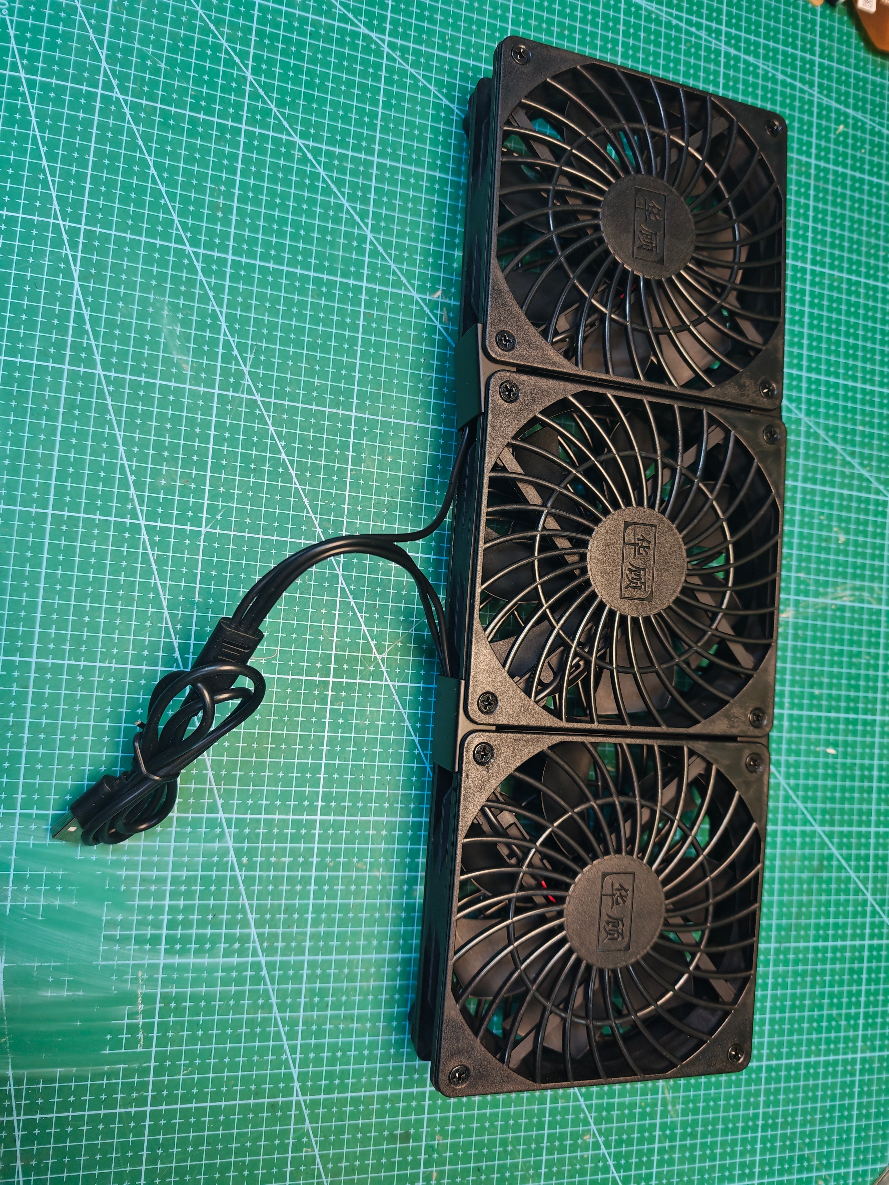 Front view of the black triple USB cooling fan unit with attached USB-A cable