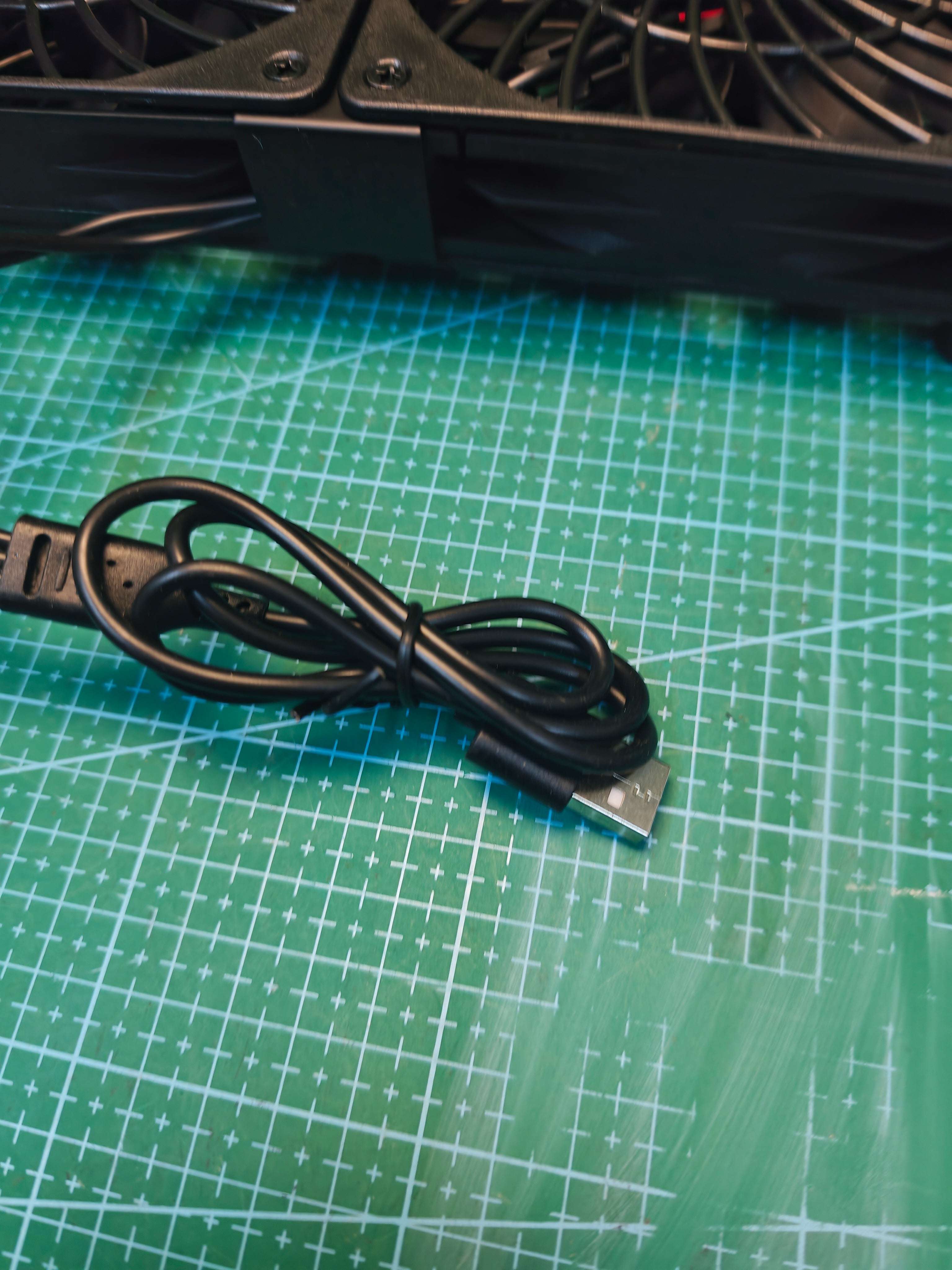 USB-A plug and attached cable on the black triple cooling fan unit