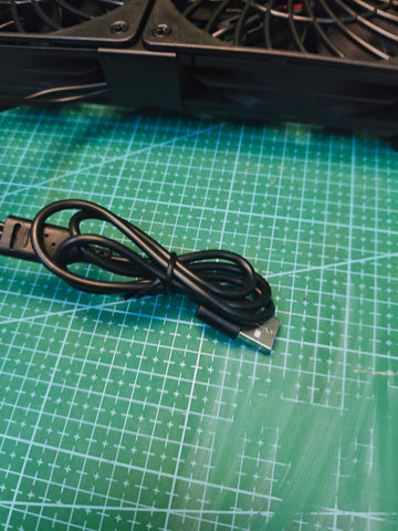 USB-A plug and attached cable on the black triple cooling fan unit