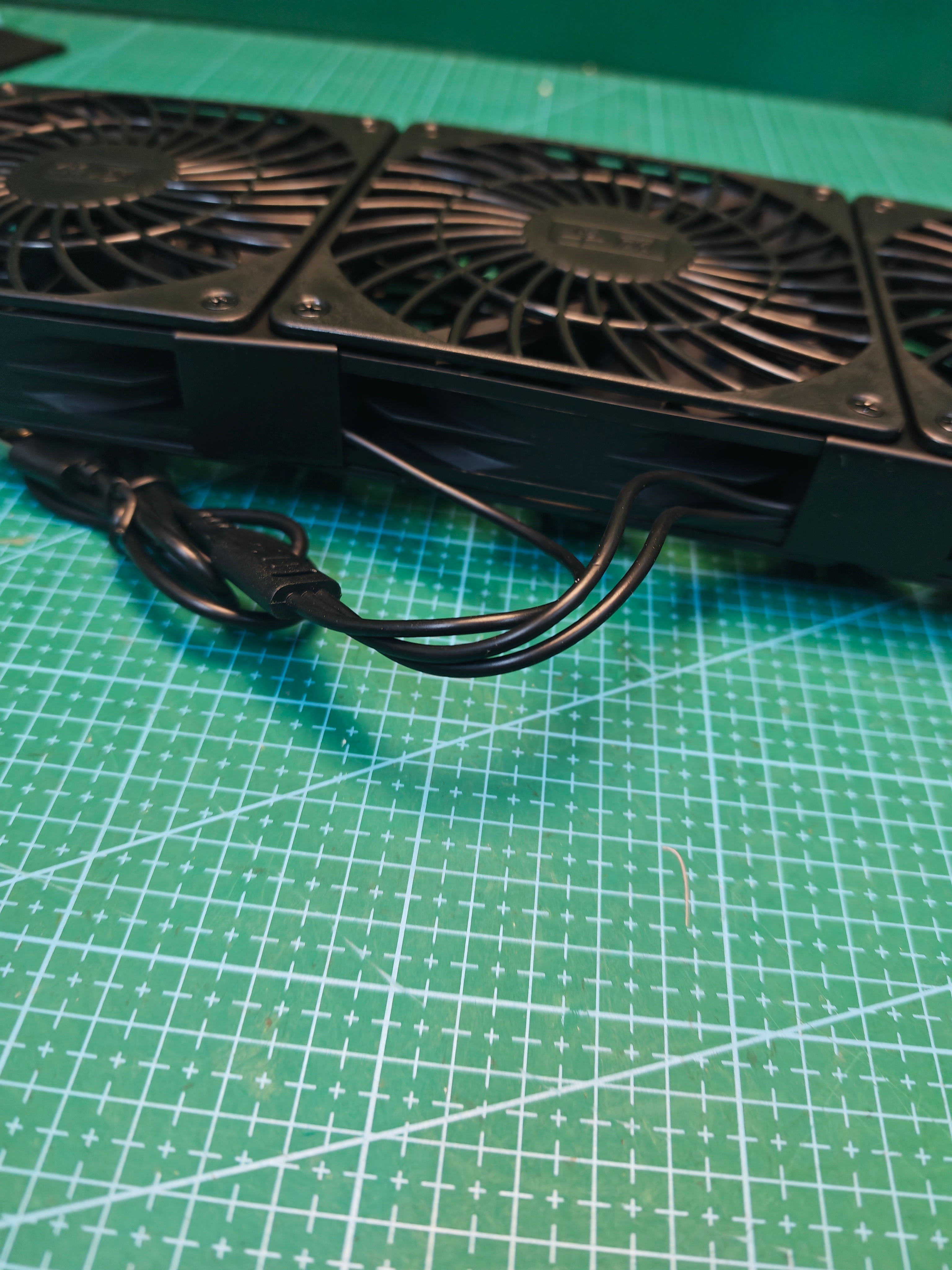 Side view of the triple USB cooling fan unit showing the joined frame and attached cable